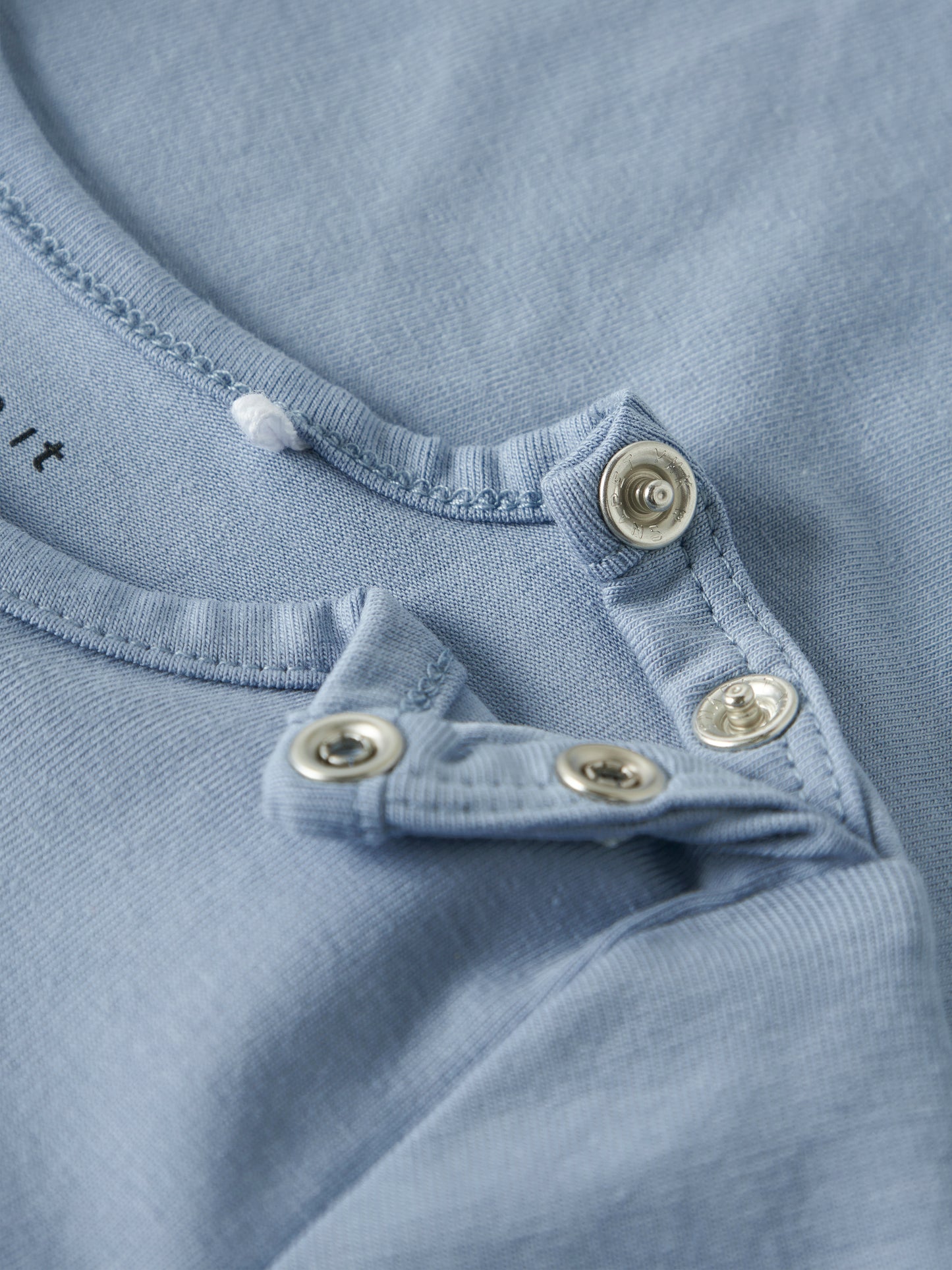 blaues Langarmshirt für Babys von name It mit Knöpfen an der Schulter und Traktormotiv - Detailansicht