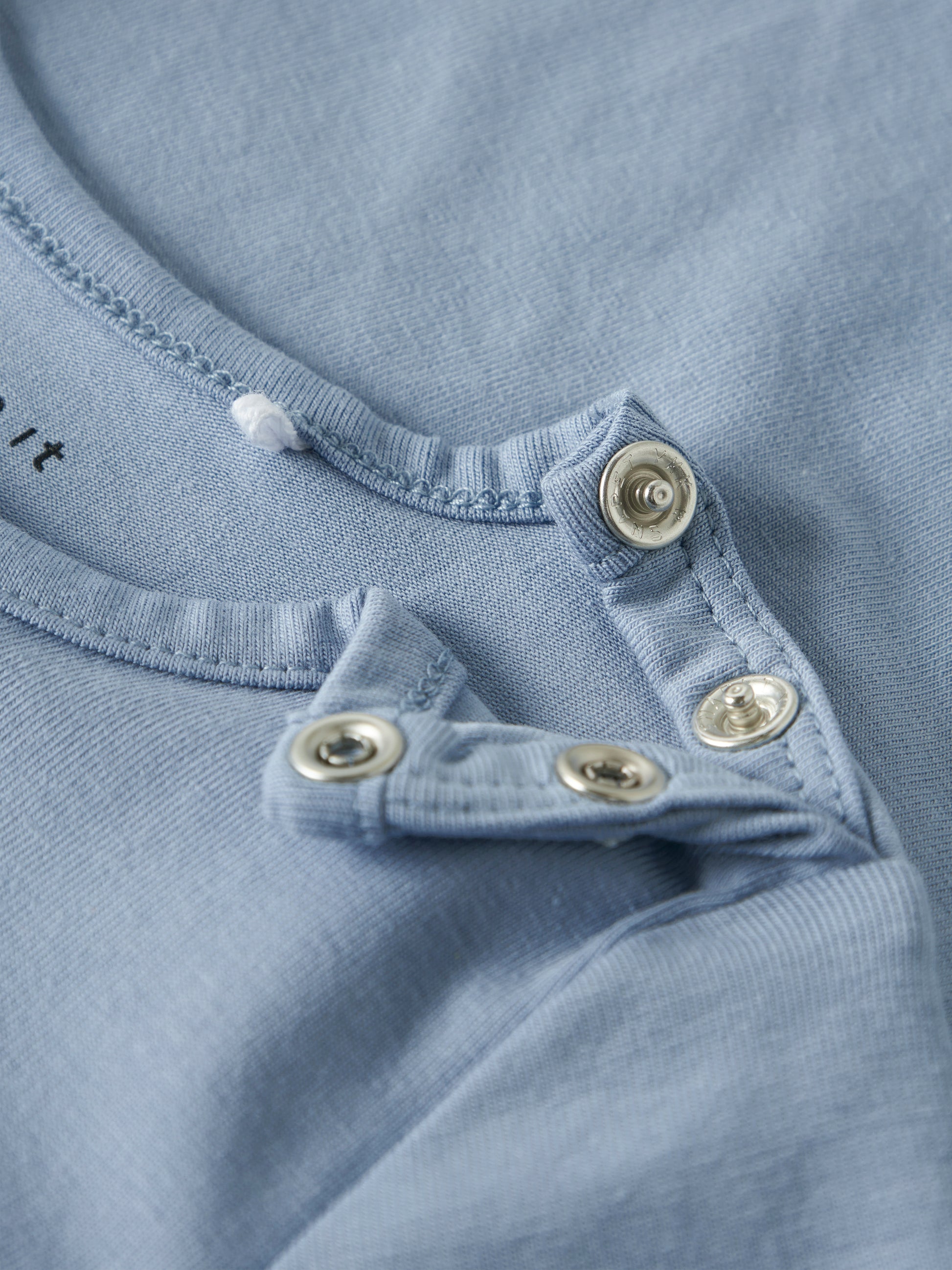 blaues Langarmshirt für Babys von name It mit Knöpfen an der Schulter und Traktormotiv - Detailansicht