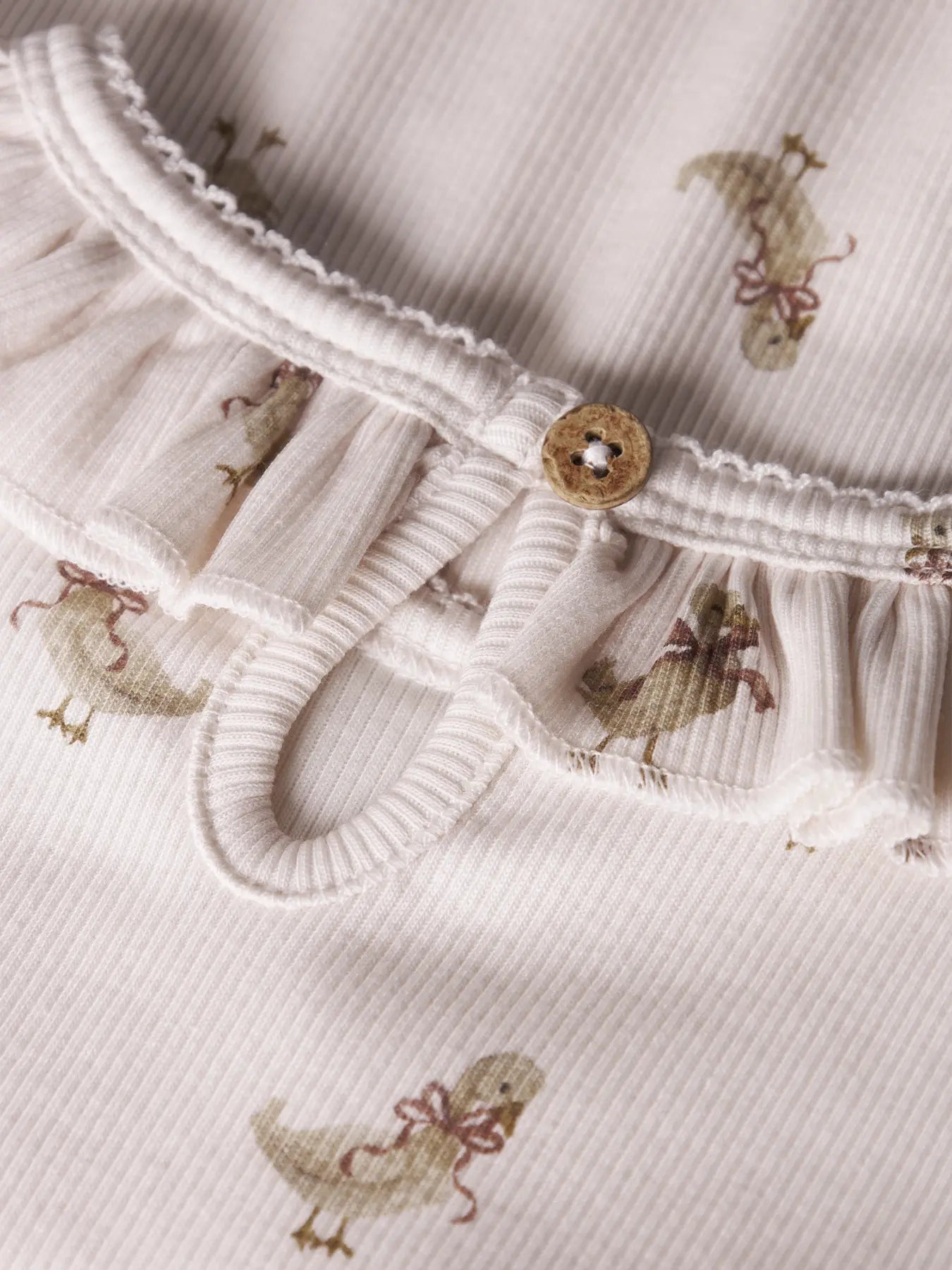 Langarmshirt in Beige natur mit kükenmotiven und rüschenkragen von lil' atelier aus bio-baumwolle und lyocell - detailansicht